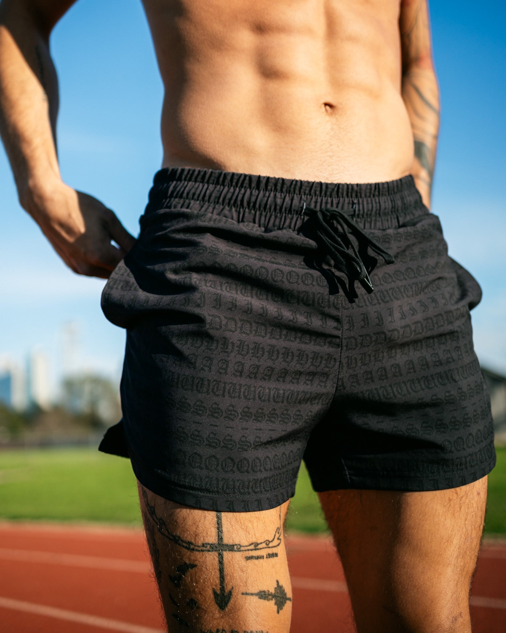 A runner standing on the track wearing a pair of men's 4 inch inseam mesh shorts from SquidHaus