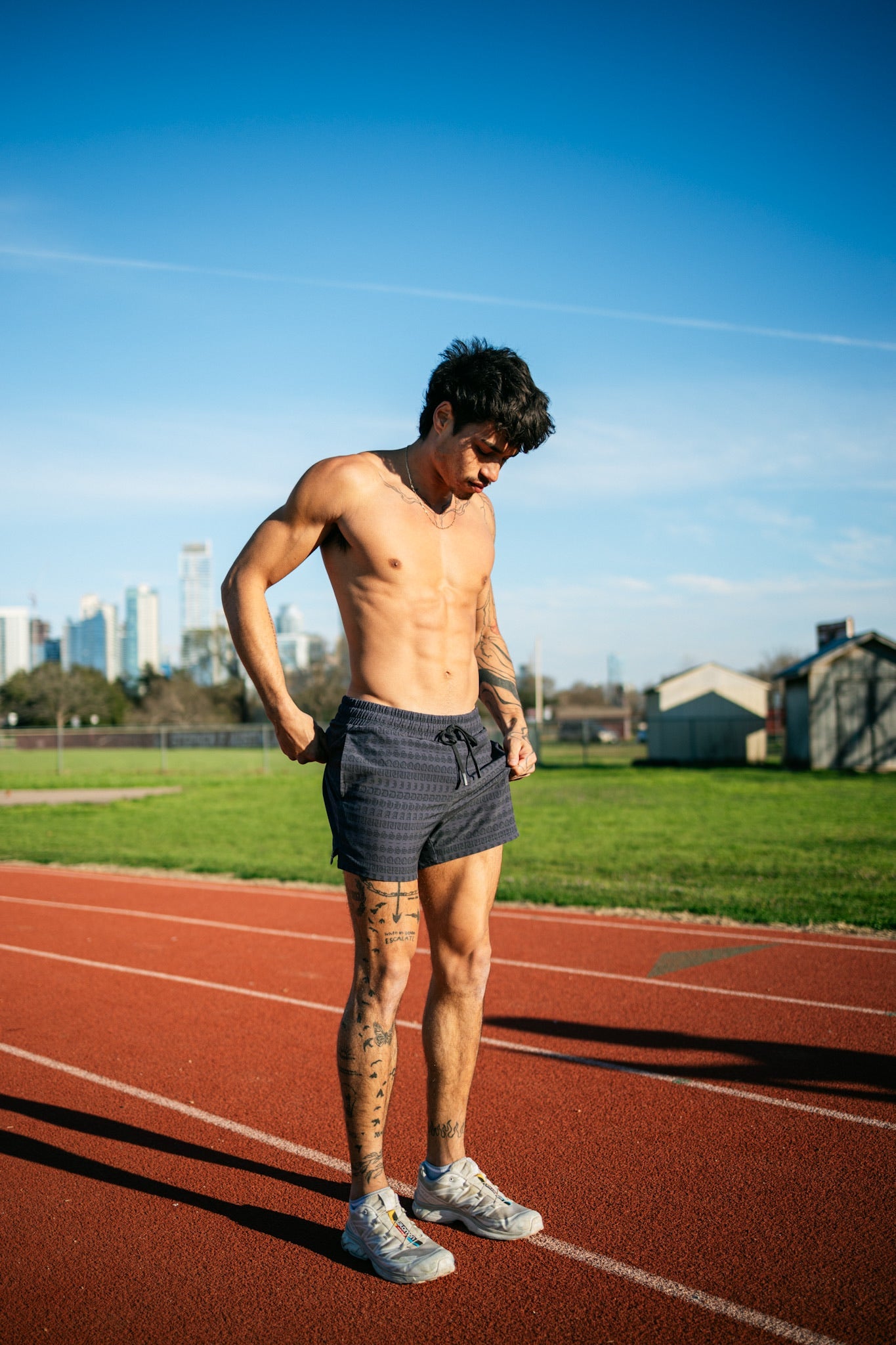 A runner getting ready to exercise on the track wearing 4 inch inseam mesh shorts from SquidHaus