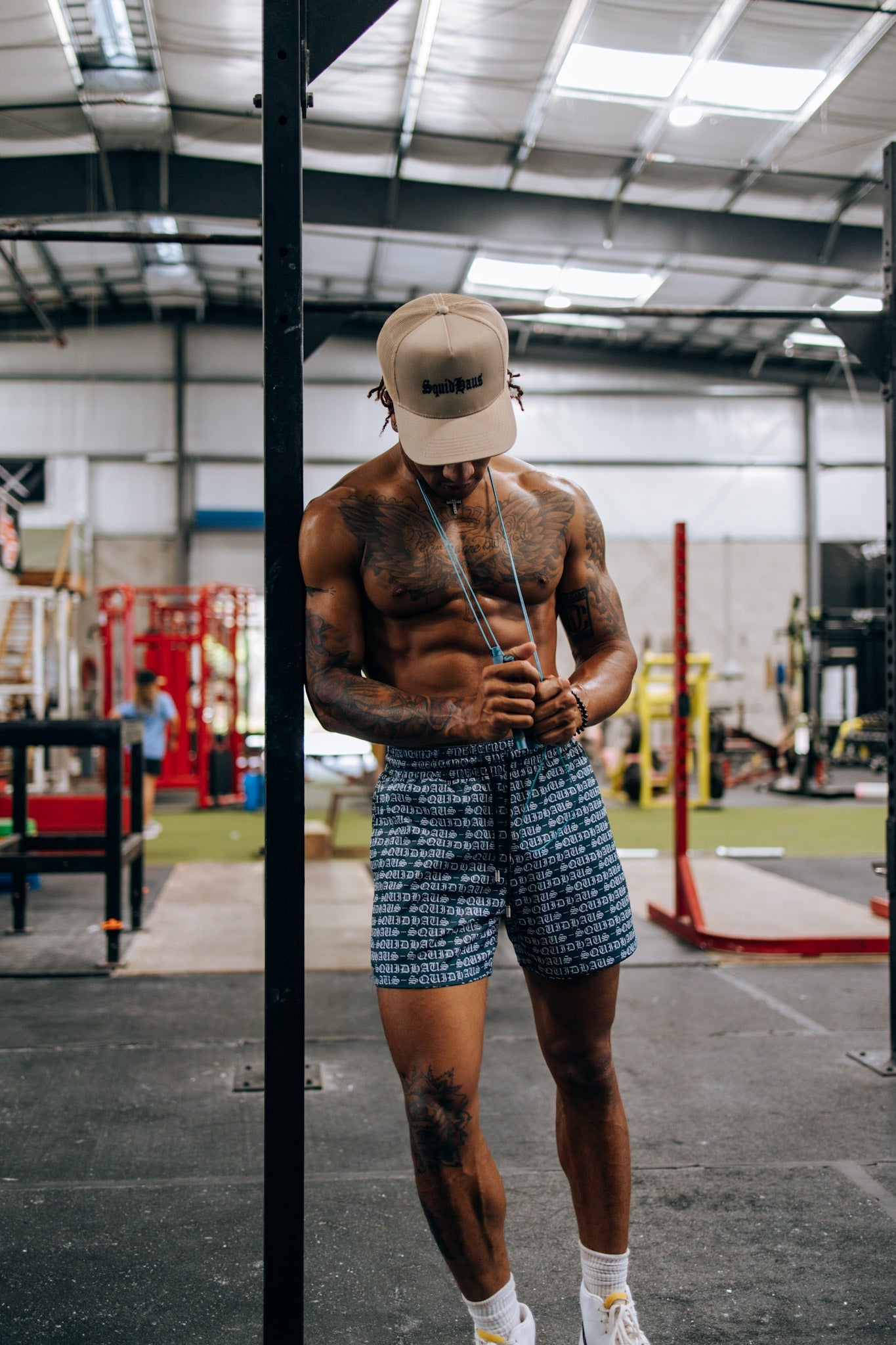 A bodybuilder at the gym wearing 4 inch inseam mesh shorts in navy blue, from Squidhaus